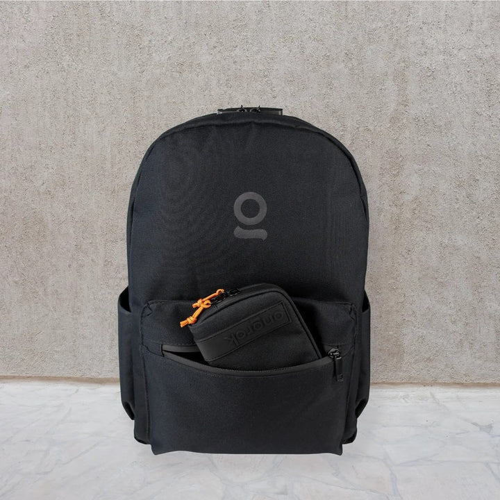 ONGROK Smell Proof Backpack in black against a concrete wall, a small pouch in the front pocket
