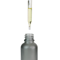 Oil-filled dropper held above an open frosted ONGROK Glass Dropper Bottle, close-up