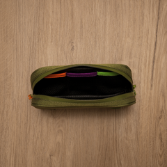 ONGROK Carbon-lined Wallet in green, medium, open on wood, top view of the color-coded pockets